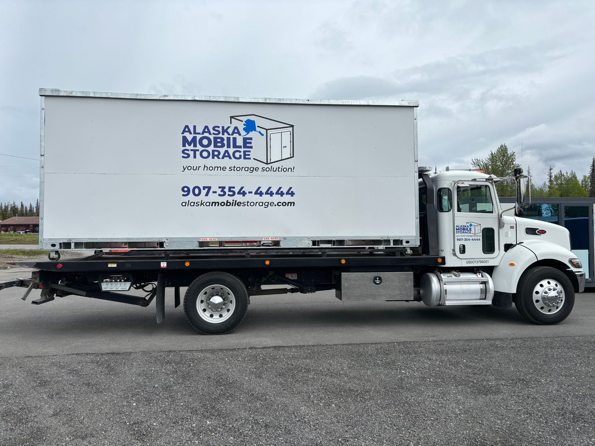 An alaska mobile storage truck is parked on the side of the road.