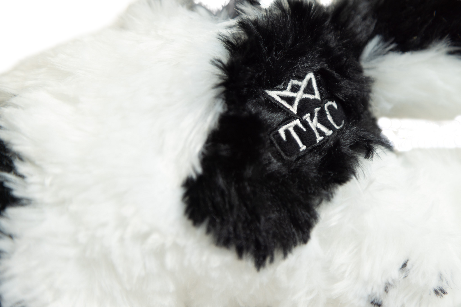 a plush toy of a dog with black and white fur