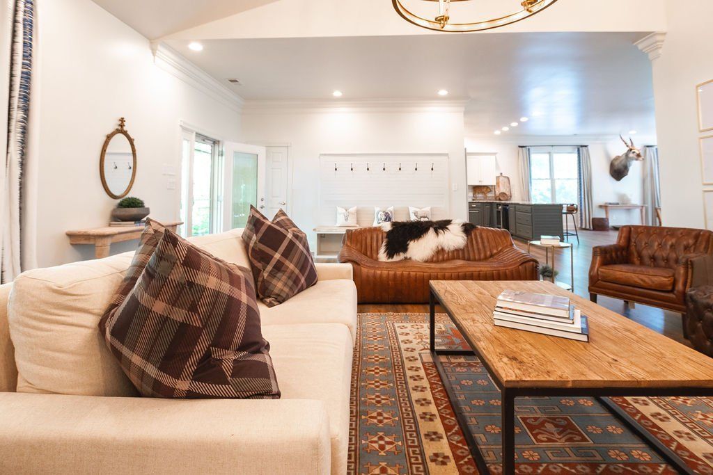 Living room with neutral color palette, leather couches, and patterned rug.