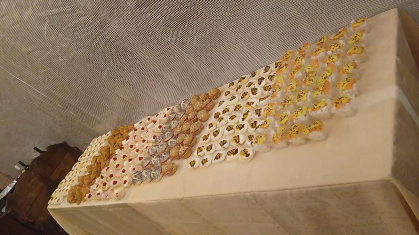 Esposizione decorativa di oggetti circolari di vari colori disposti su una superficie bianca, con uno sfondo a rete.