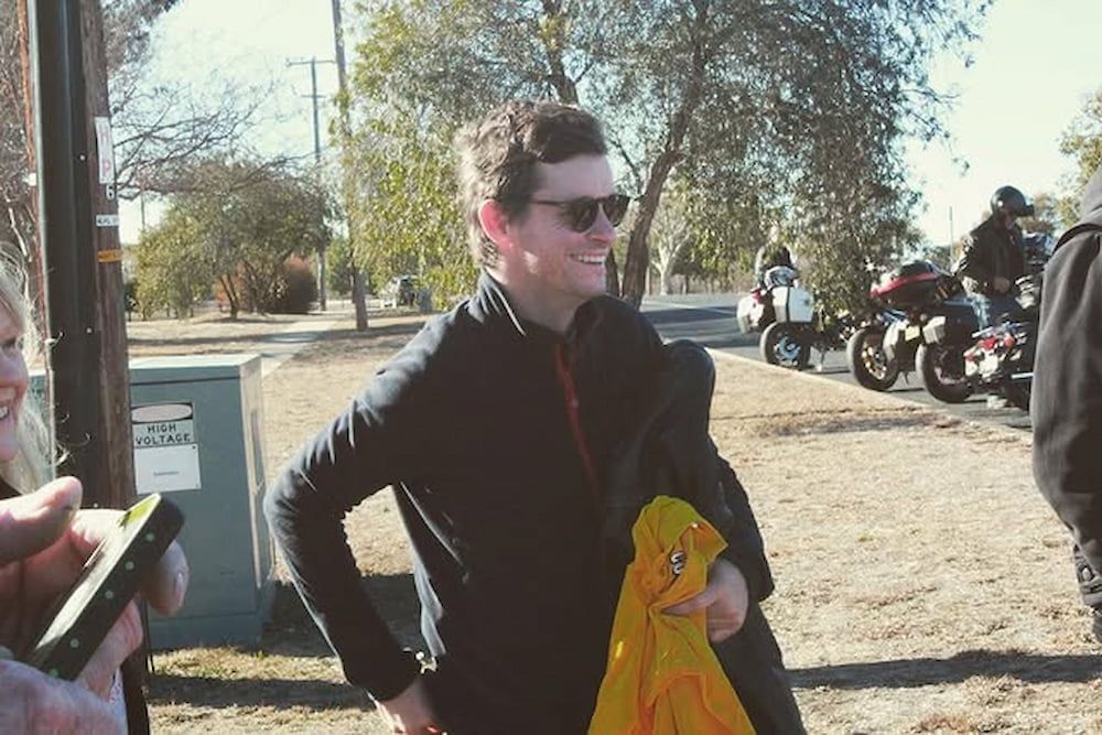 A Man Wearing Sunglasses Is Standing In A Field With Motorcycles — Inverell Sporties in Inverell, NSW