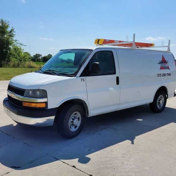 White utility van parked on a sunlit road, with orange lights and a logo on the side.