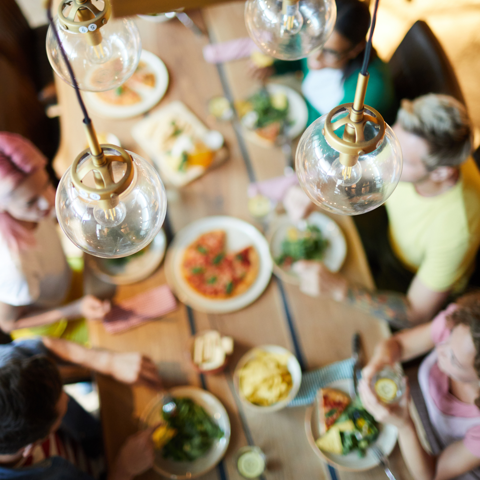 A group of people are sitting around a table with plates of food.