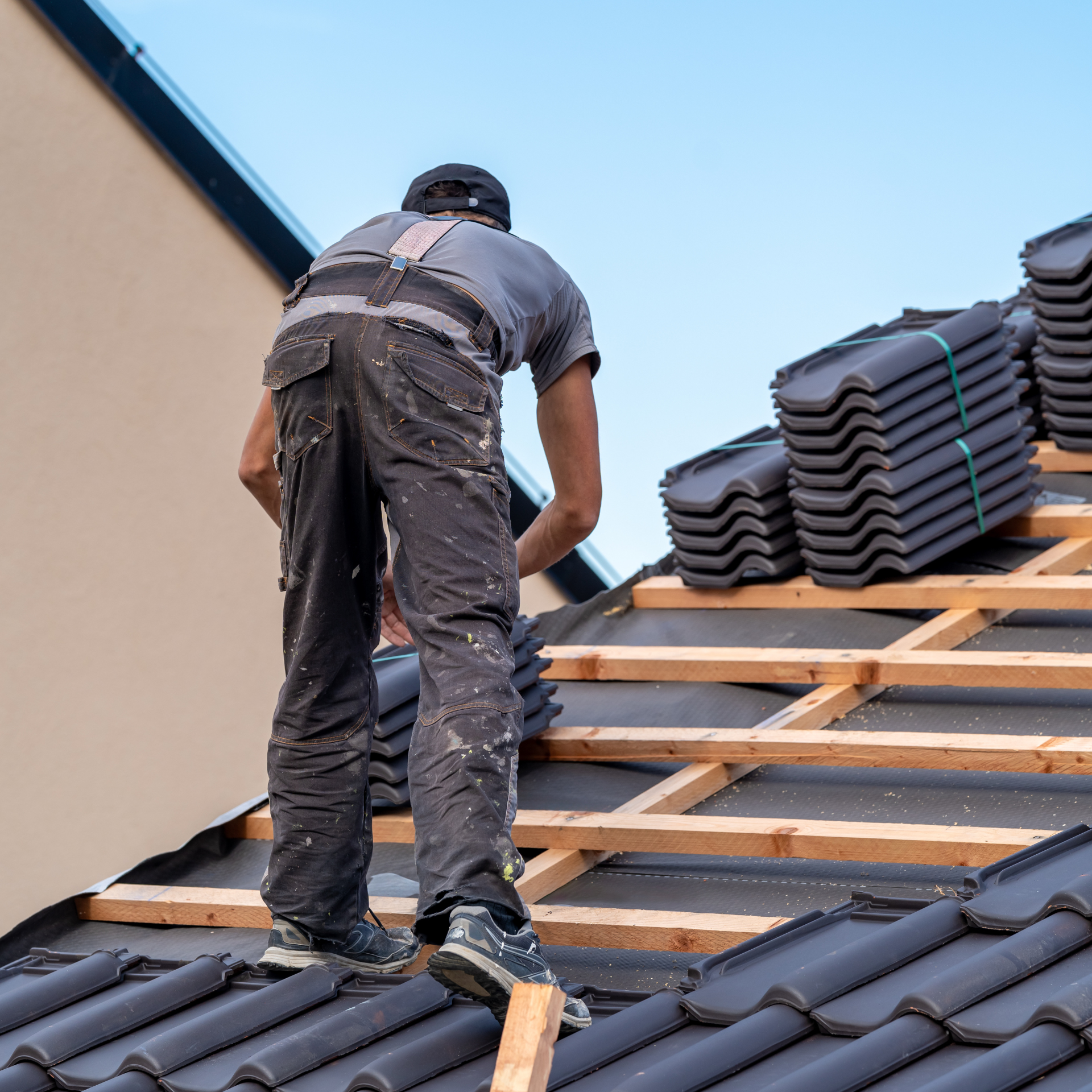 A man is working on the roof of a house.
