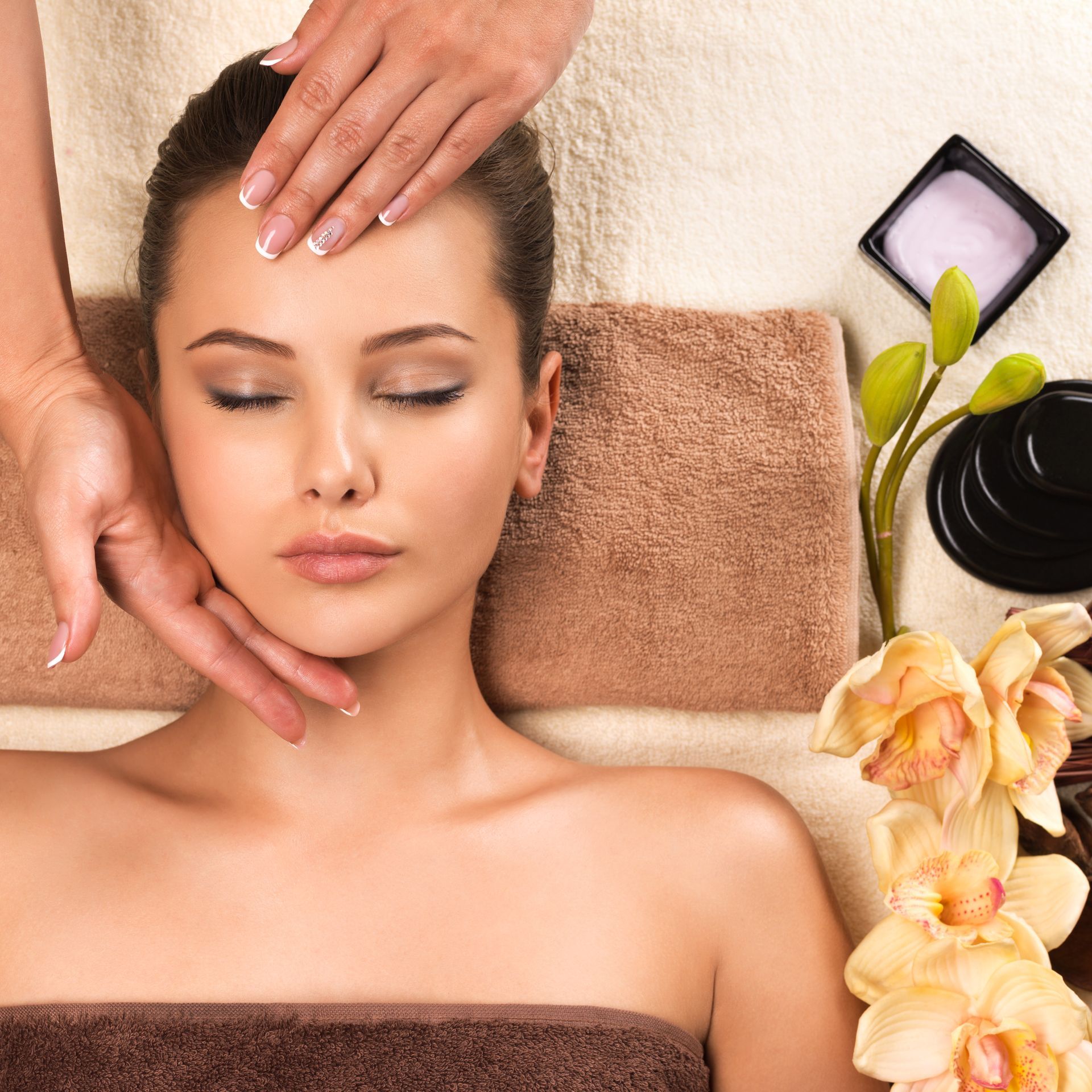 A woman is getting a head massage with her eyes closed