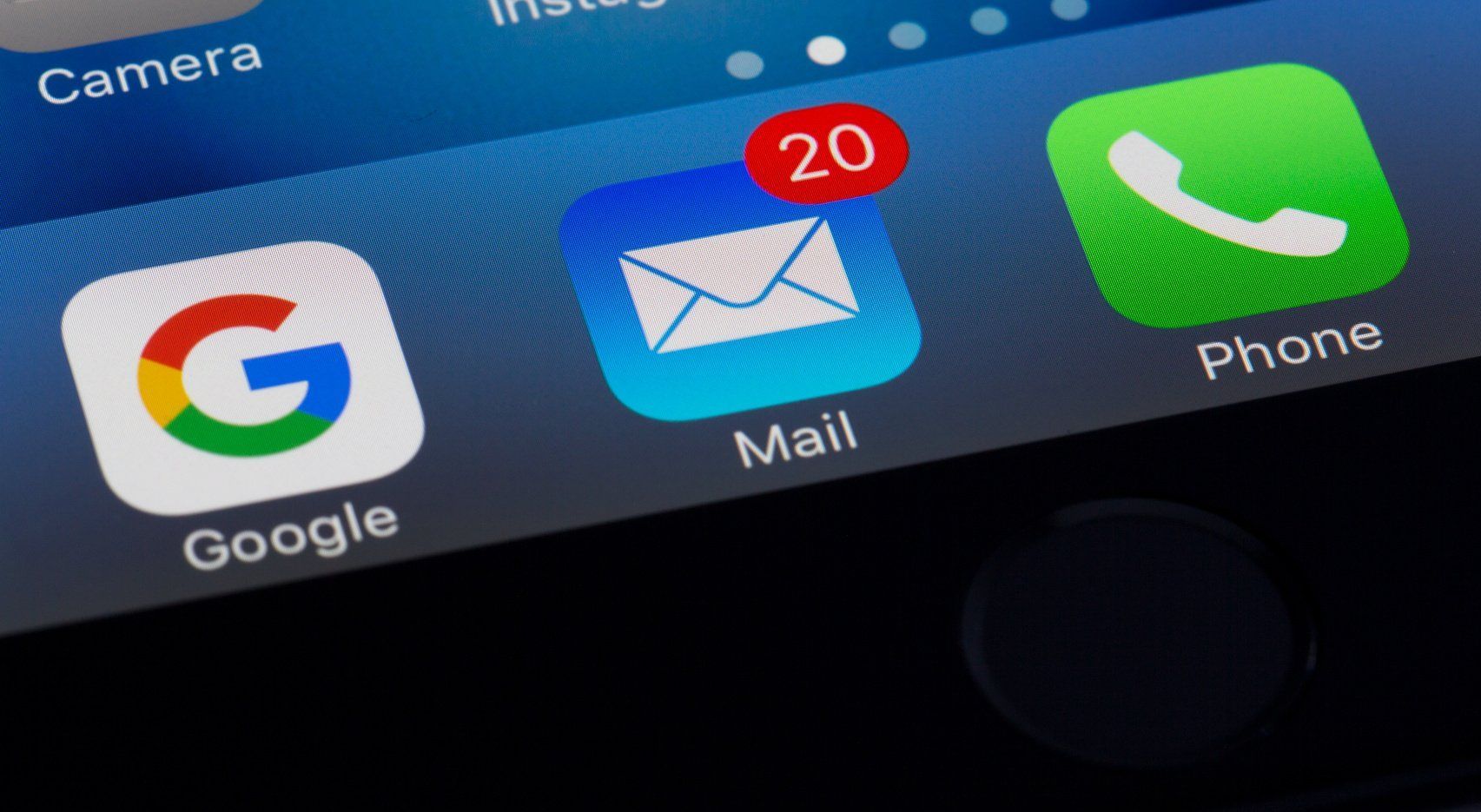 A close up of a cell phone screen showing the icons for google , mail , and phone.