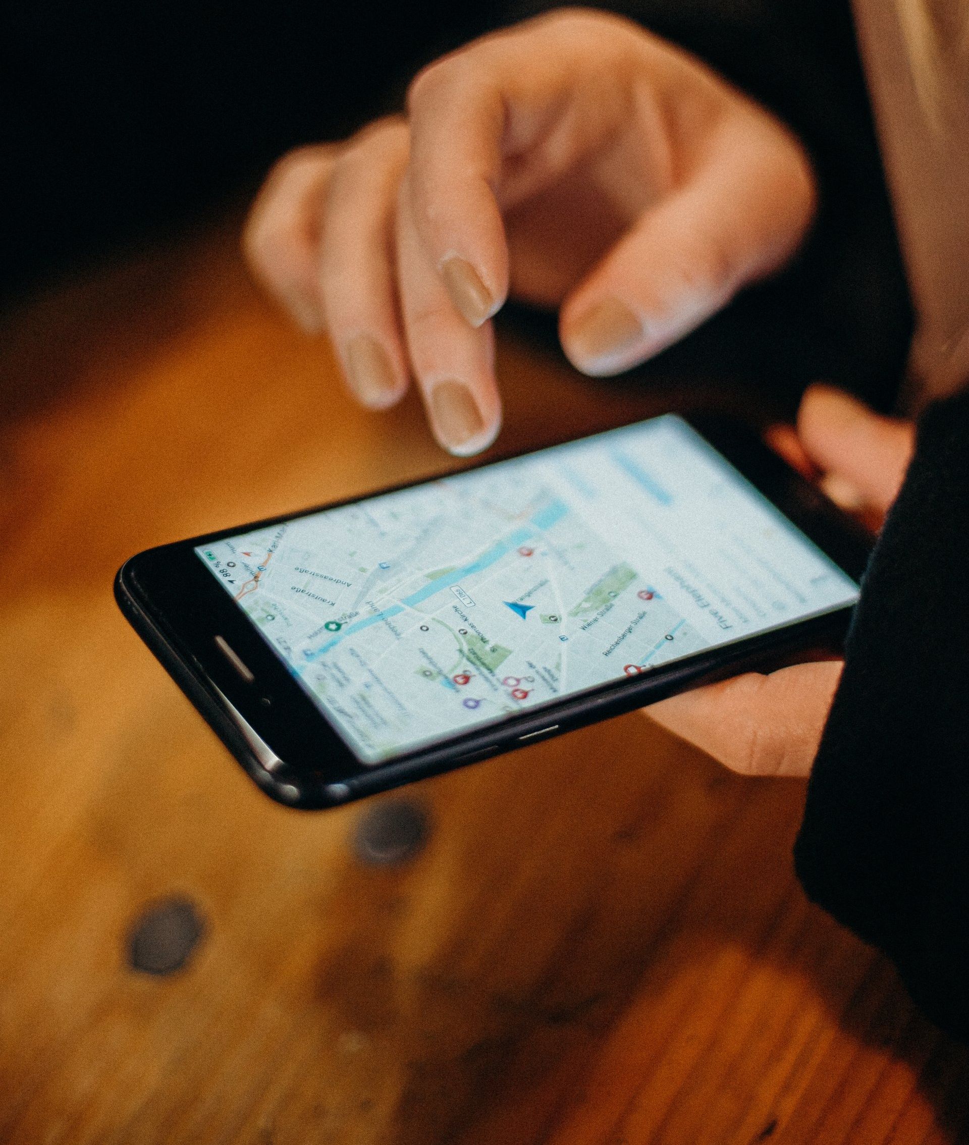 A person is holding a cell phone with a map on the screen.