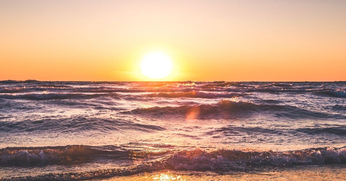 The sun is setting over the ocean.
