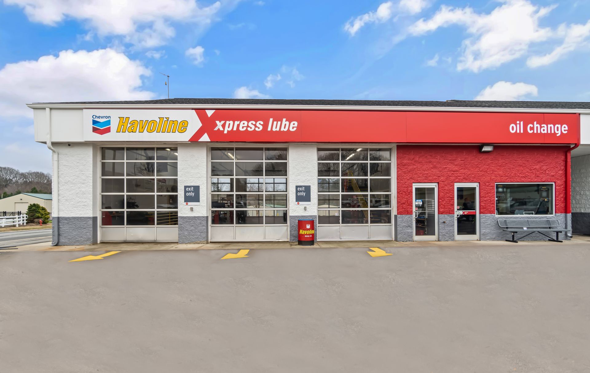 Red Chevron Xpress lube and oil change storefront with garage bays and parking spaces