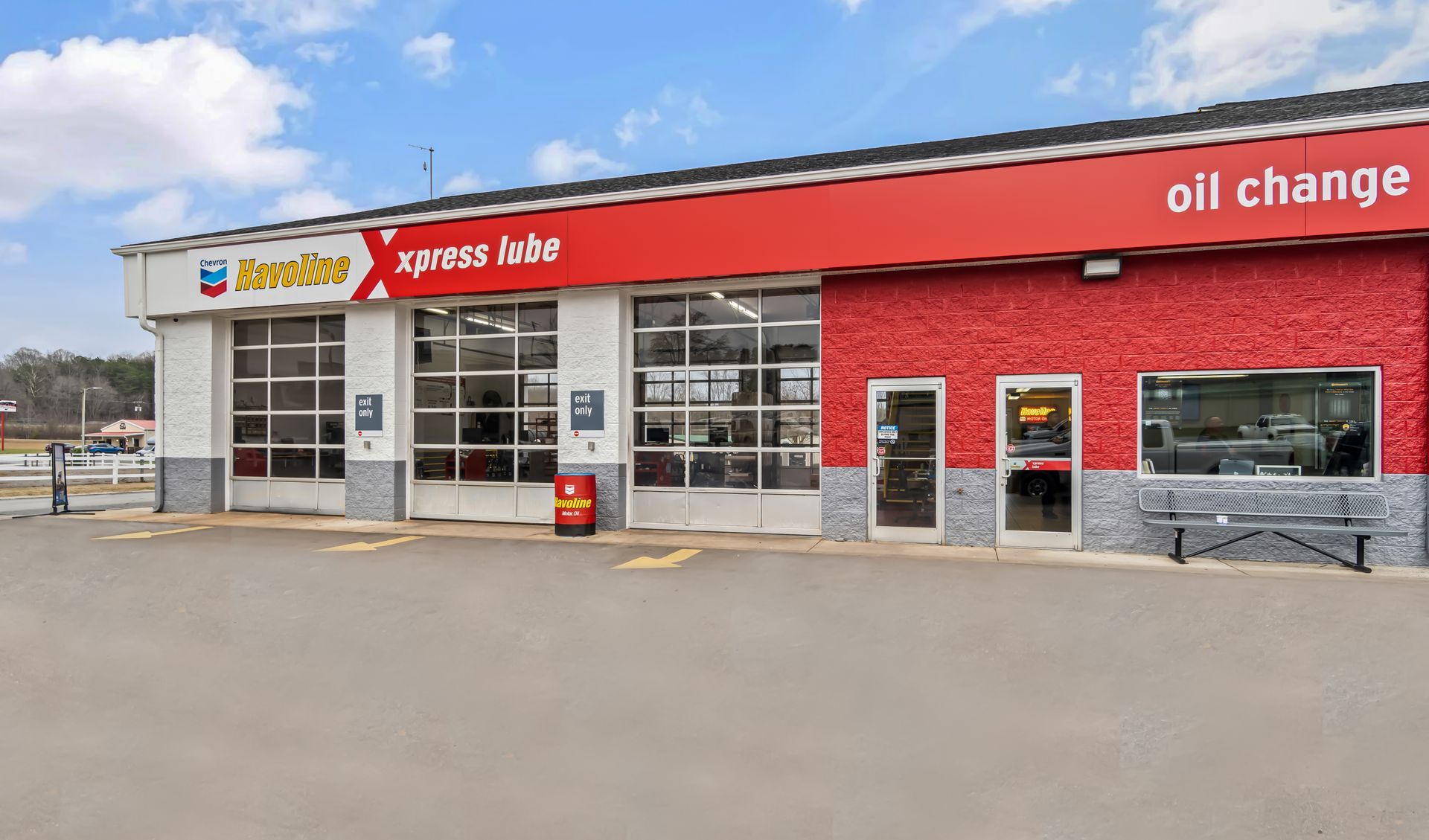 Exterior of an Xpress Auto oil change shop with red awning and service bays