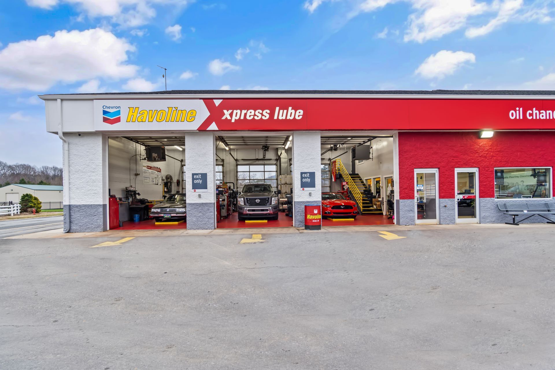 Red-and-white Xpress Lube auto service shop with garage bays and cars inside