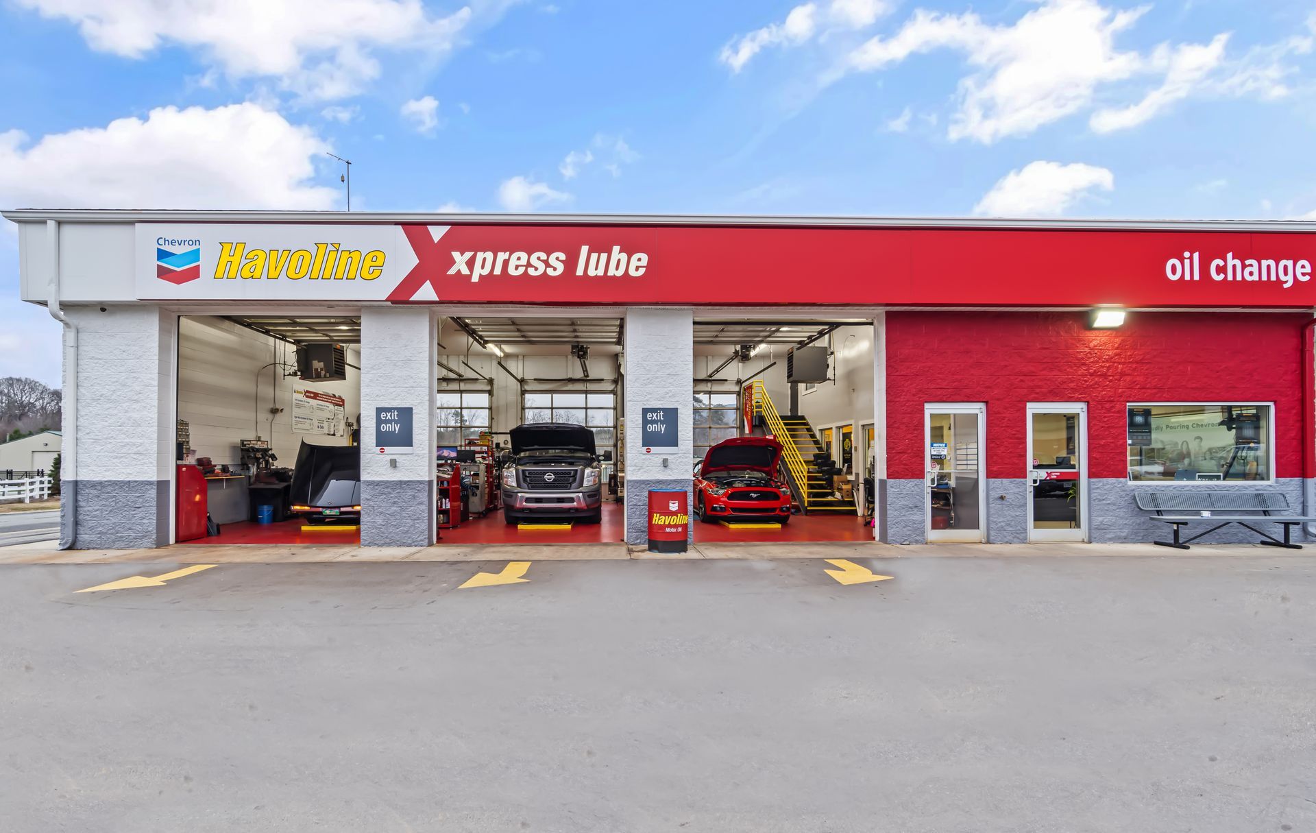 Xpress Lube oil change shop with red and gray exterior and cars in service bays