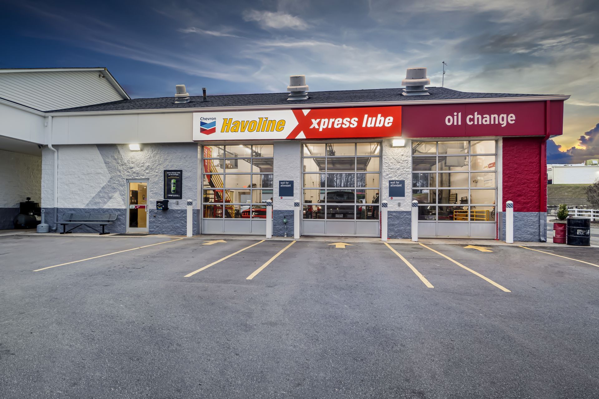 Kwik Stop Xpress Lube oil change shop exterior with glass garage bays and parking spaces