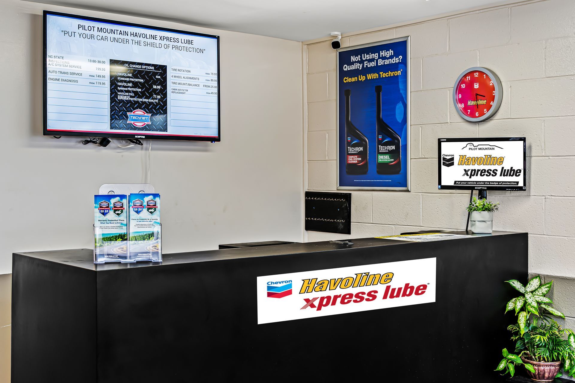 Xpress Hub service counter with menu screens, posters, and digital clock in a clean lobby