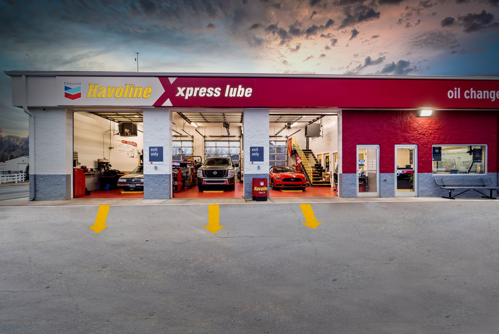 Shell station with Xpress Lube garage bays, cars inside, and a wide parking area