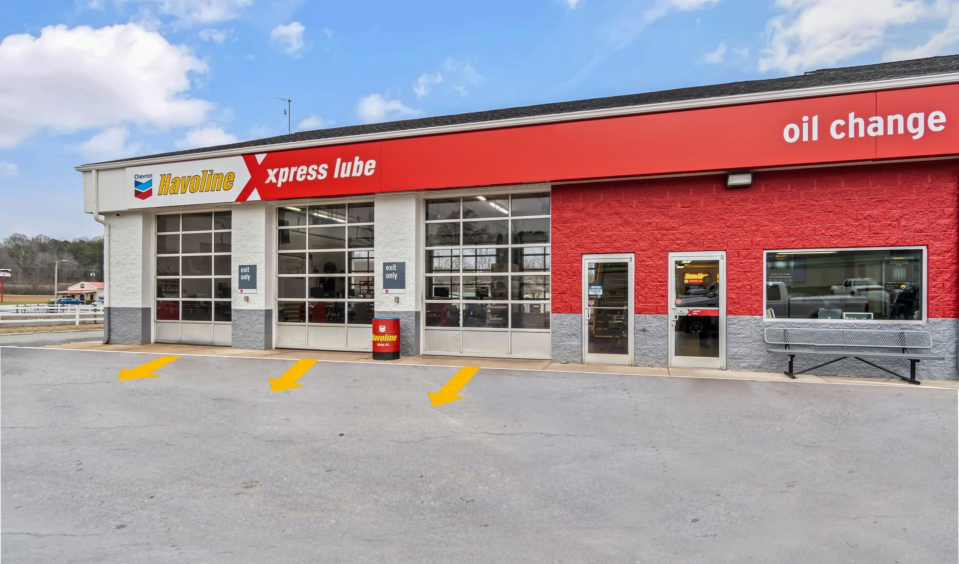 Exterior of an Xpress Auto oil change shop with a red facade and garage bays