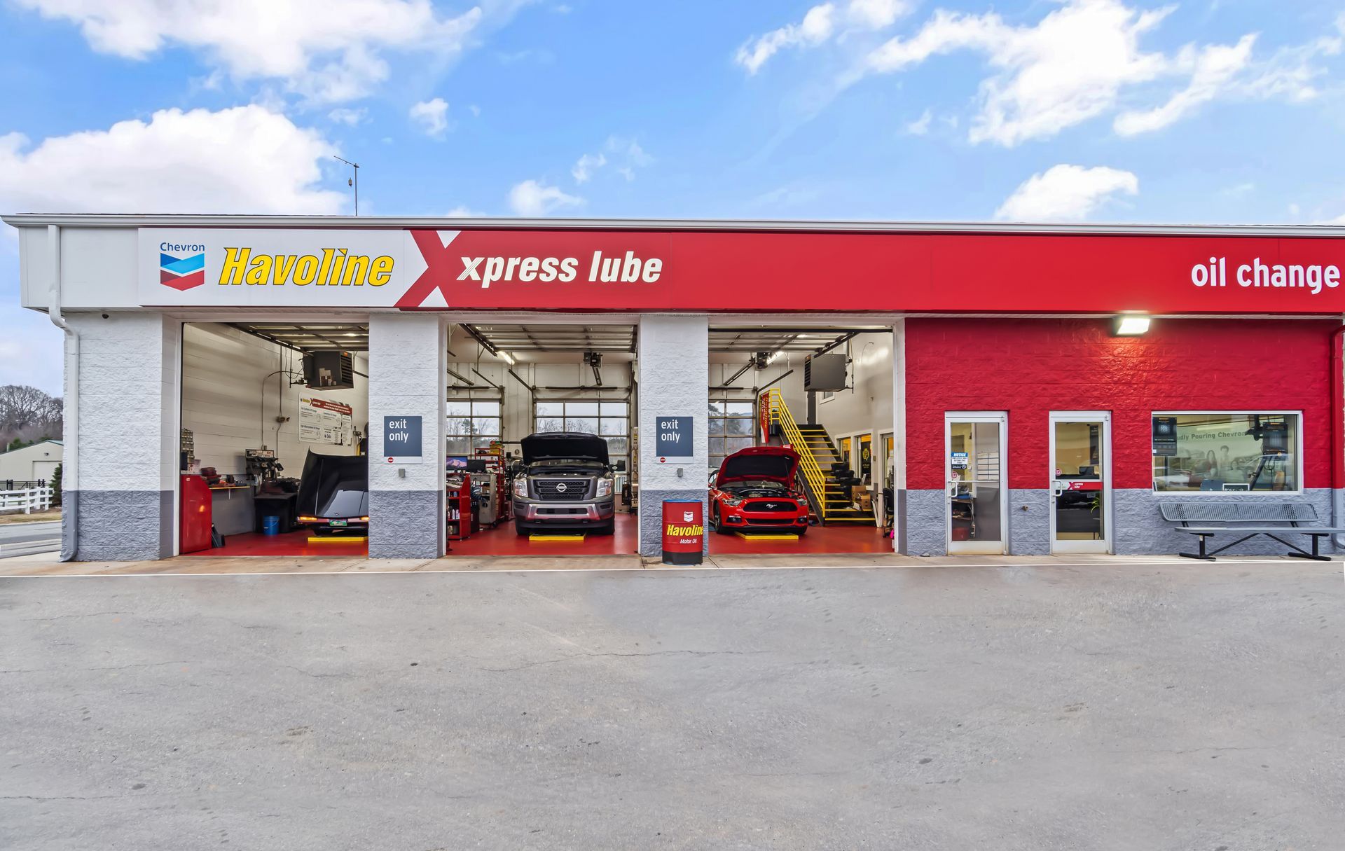 Xpress Lube oil change shop with open bays and cars parked inside under a red storefront sign