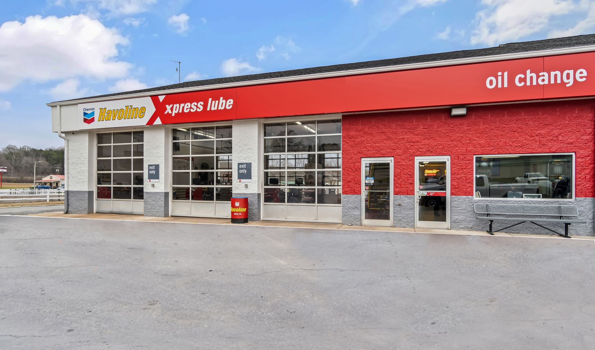 Exterior of an Express Auto oil change shop with red awnings and garage bays on a cloudy day