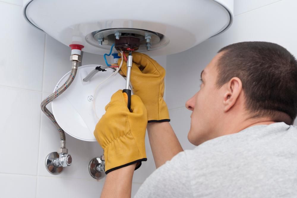 A Man Is Fixing A Wall Light Bulb — Chris North Electrical In Pomona, QLD