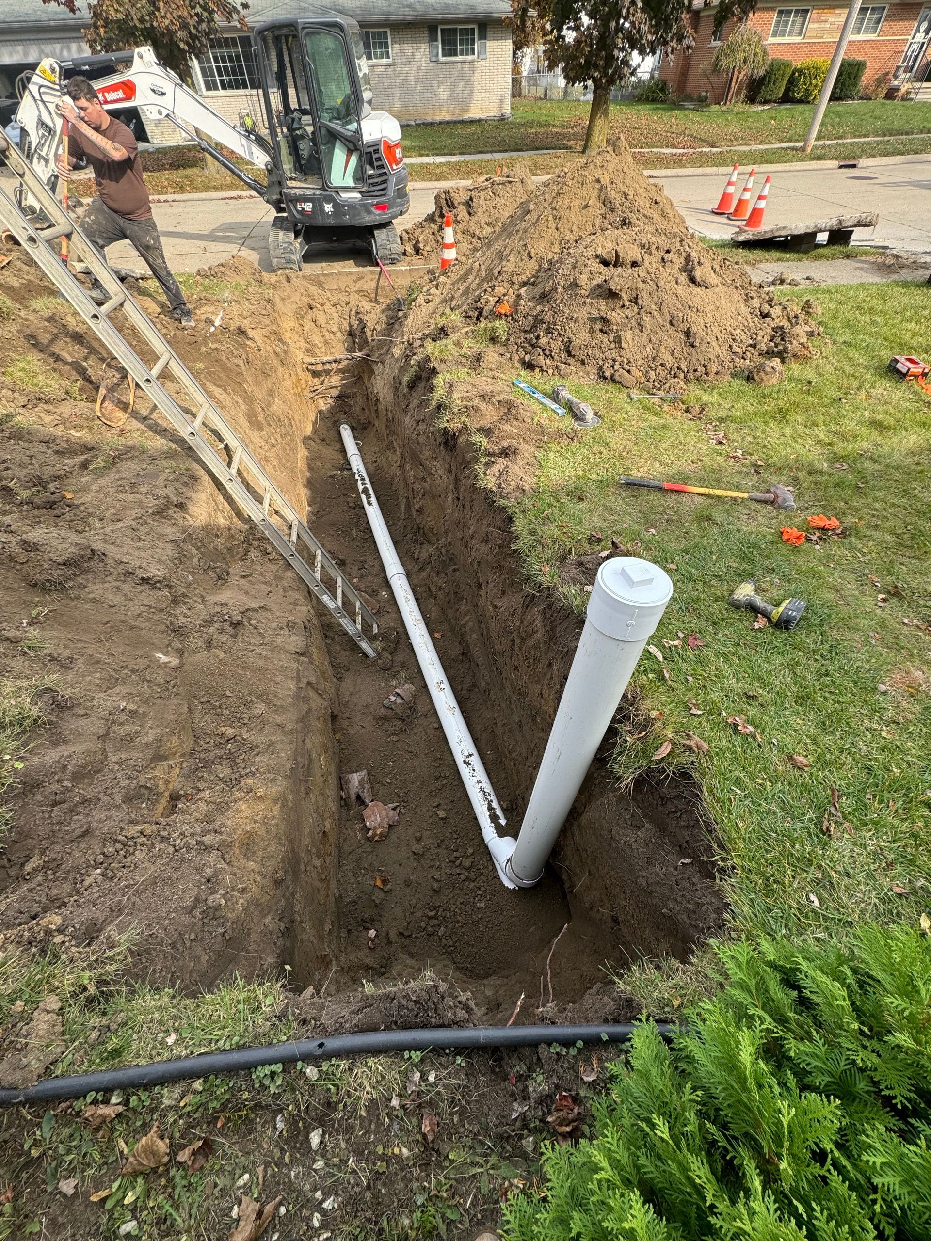 Licensed plumber repairing sewer line at excavation access point in Southeast Michigan.