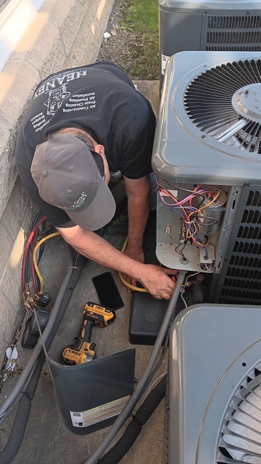 Technician completing a final AC system check after installation in Sterling Heights, Michigan.