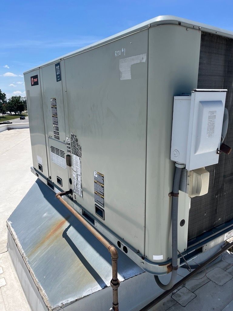HVAC technician servicing a central air conditioning condenser