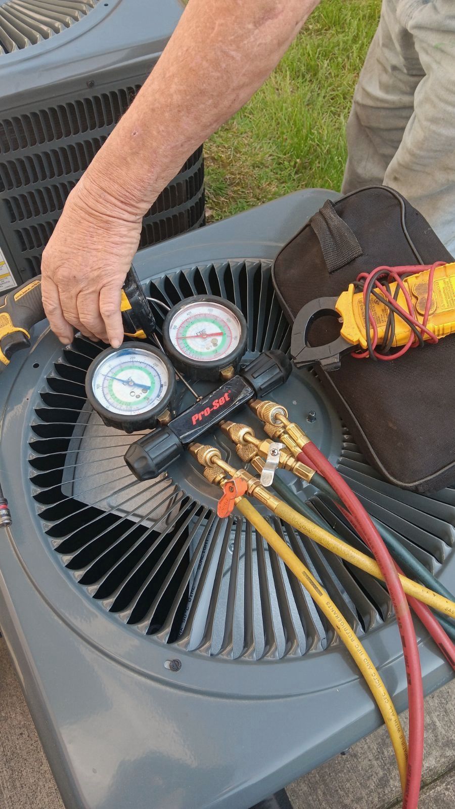 Hands removing the front cover of a wall-mounted air conditioner for cleaning.