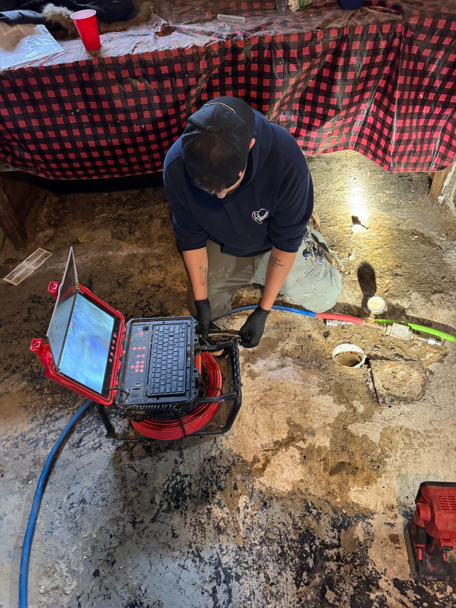 Plumber operating sewer camera inspection equipment