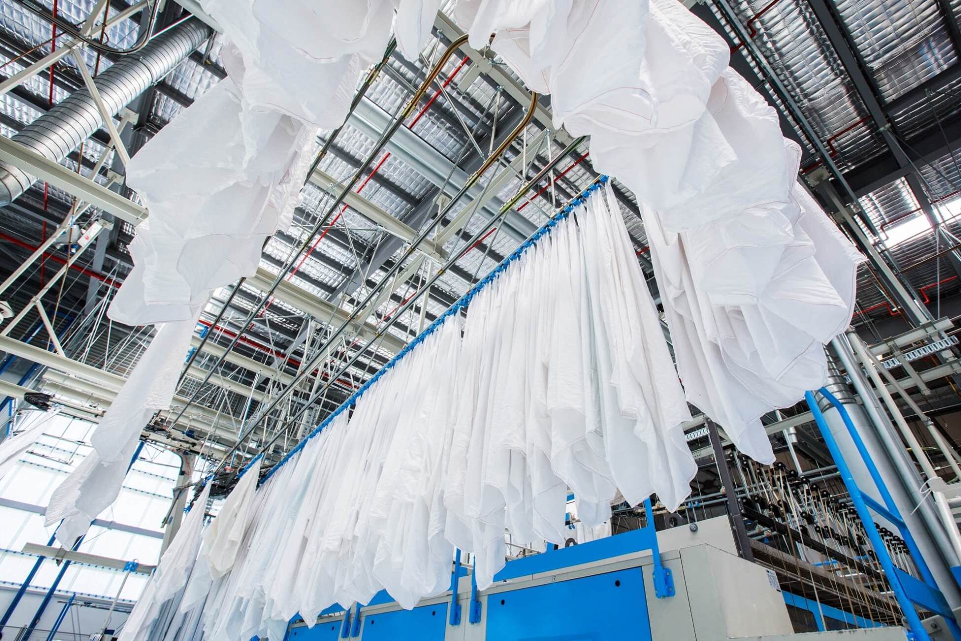 un mucchio di vestiti appesi al soffitto in una fabbrica .