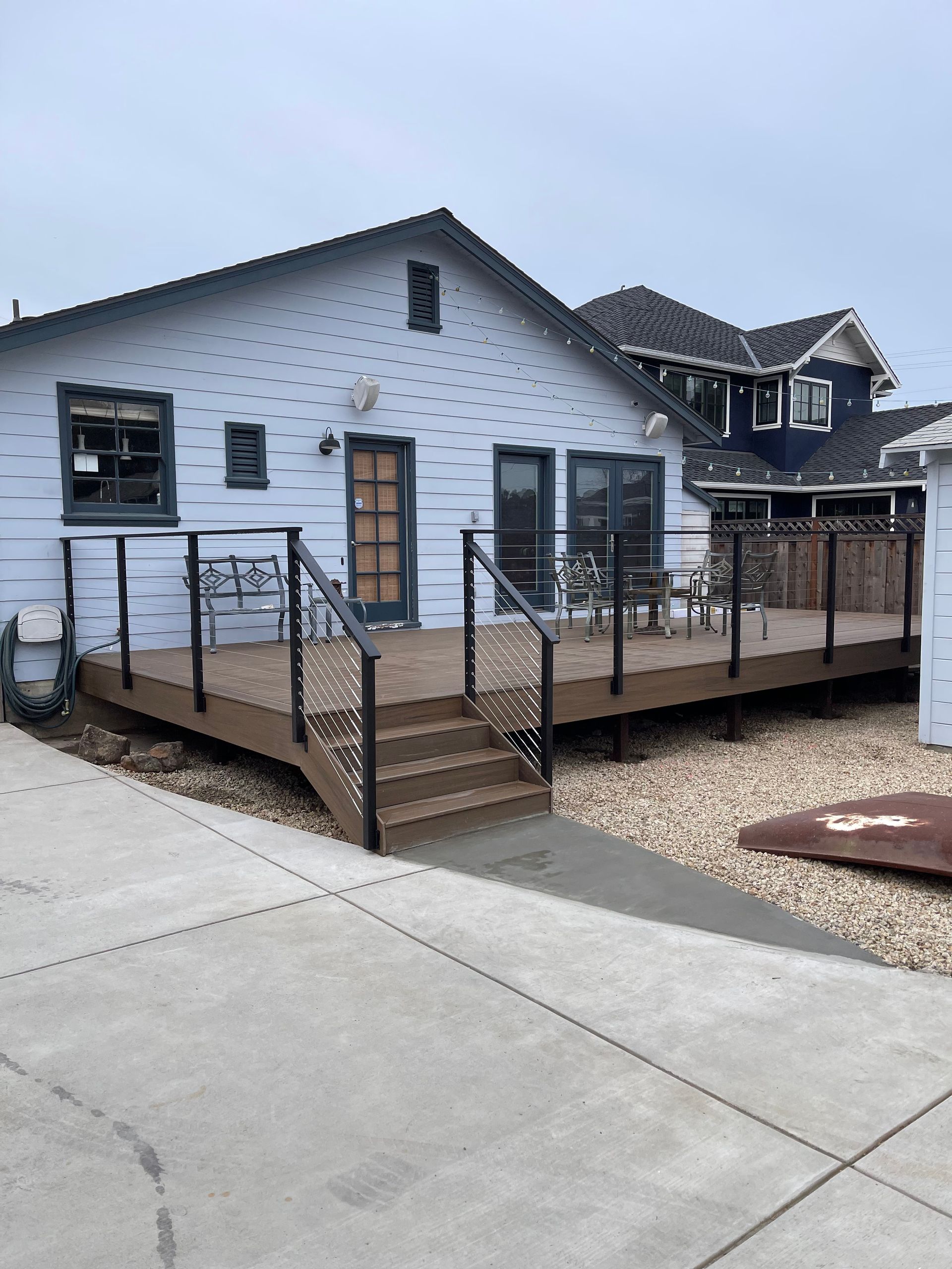 Accessible ramp and wooden deck leading to a white house entrance under construction.