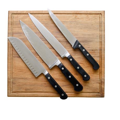 Four knives are lined up on a wooden cutting board