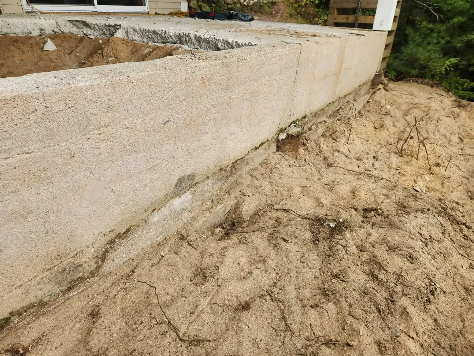 Concrete wall adjacent to a dirt mound.