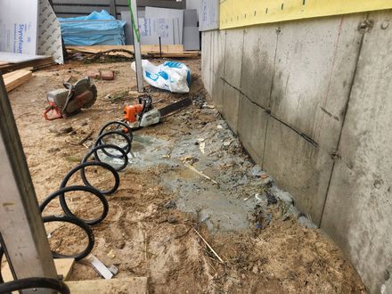 Two construction workers are cutting concrete with a circular saw.