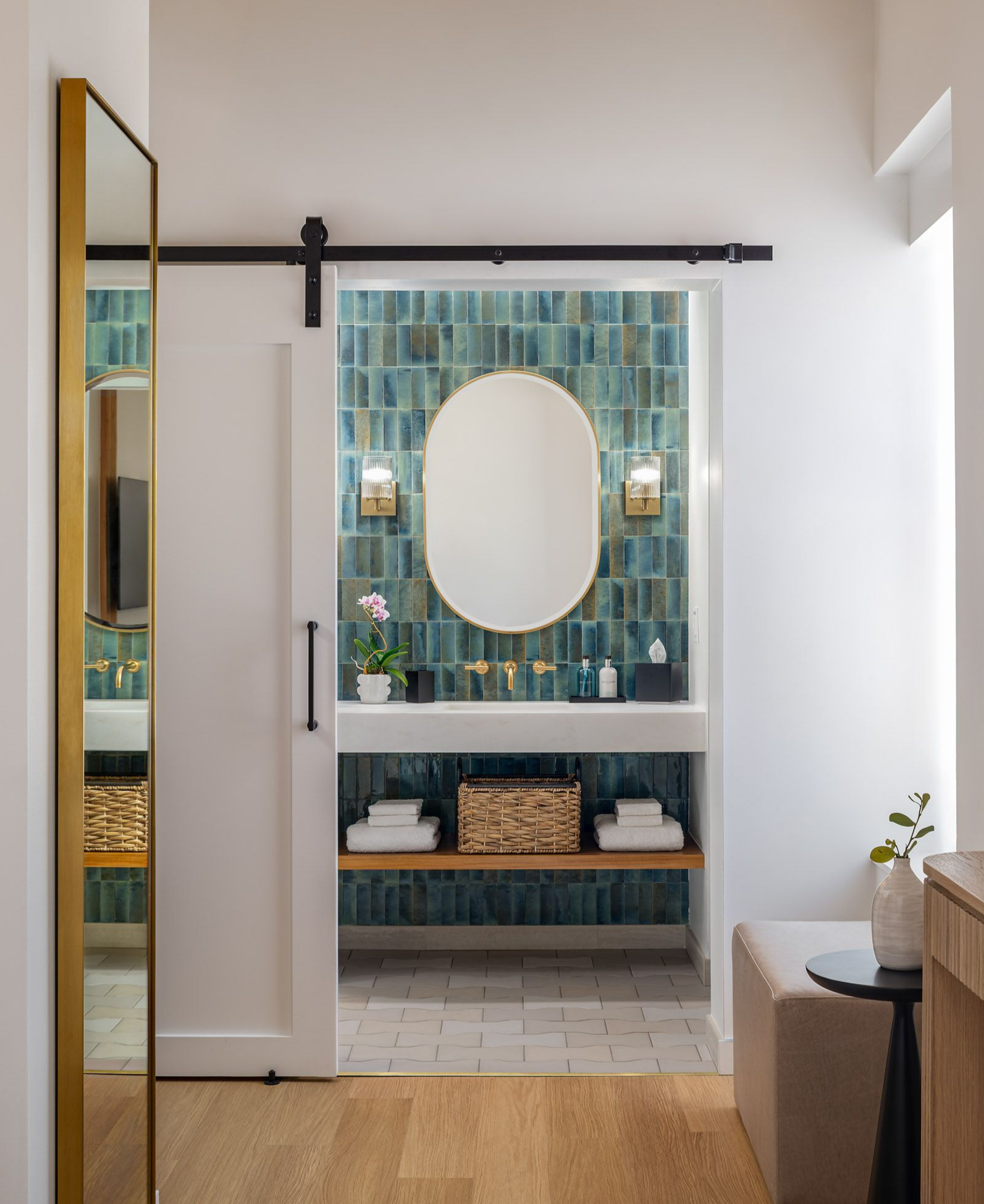 Modern bathroom with glass shower, wall mirror, sink, and toilet in beige tones