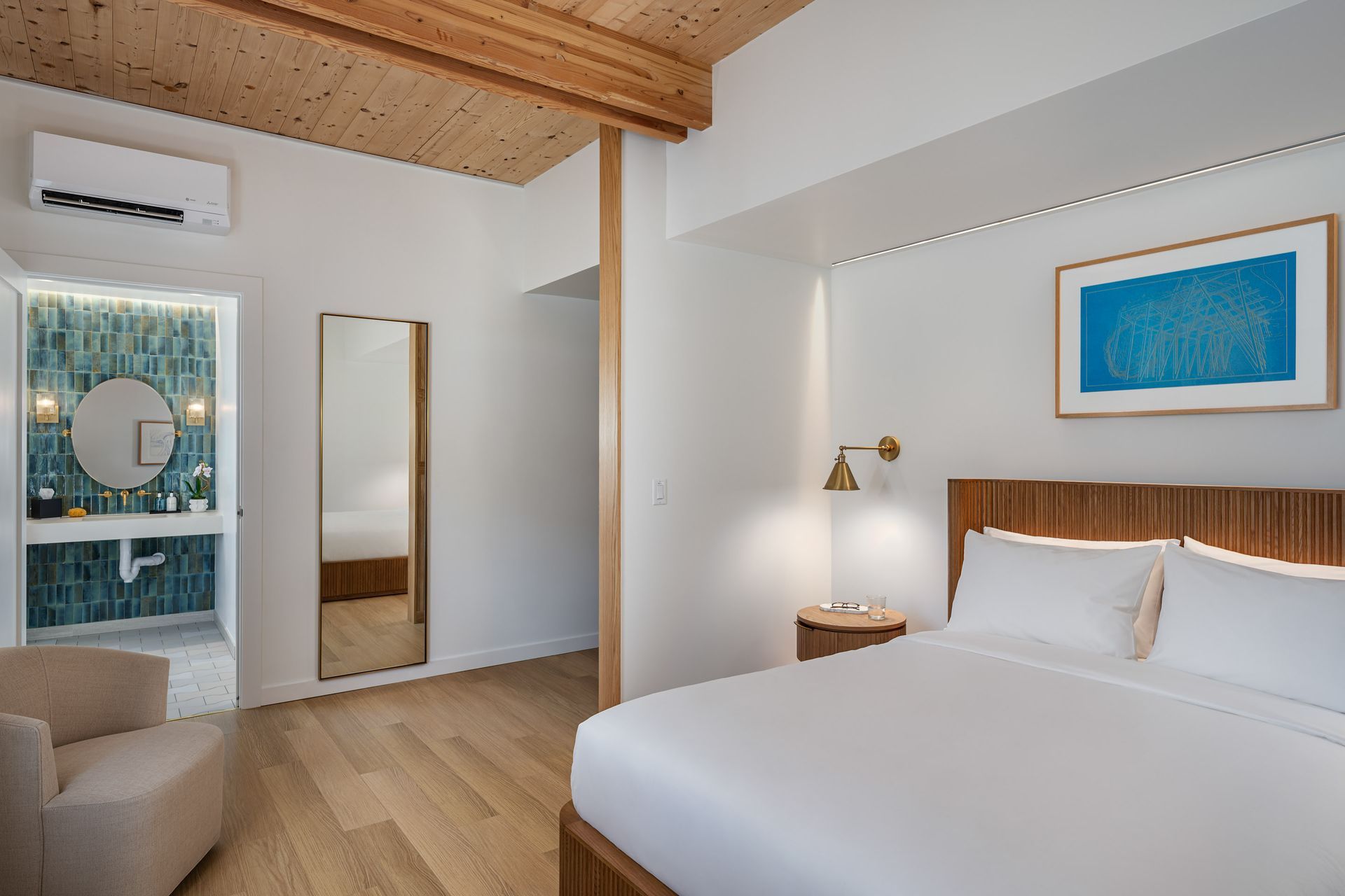 Bedroom with wood paneling, sliding glass door to bathroom, and neutral colors.