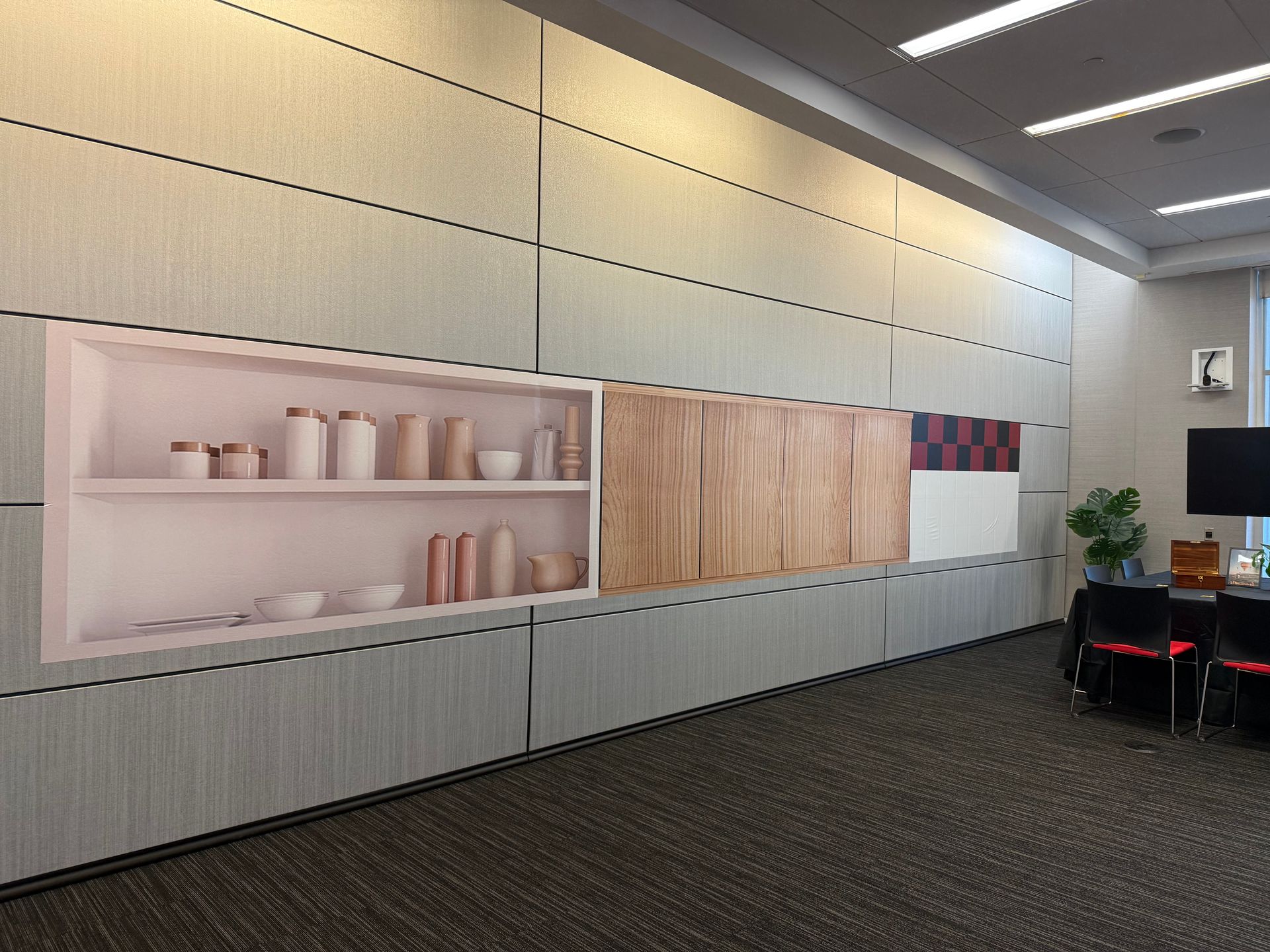 Modern office lounge with built-in shelves, wooden panels, and chairs in a bright interior