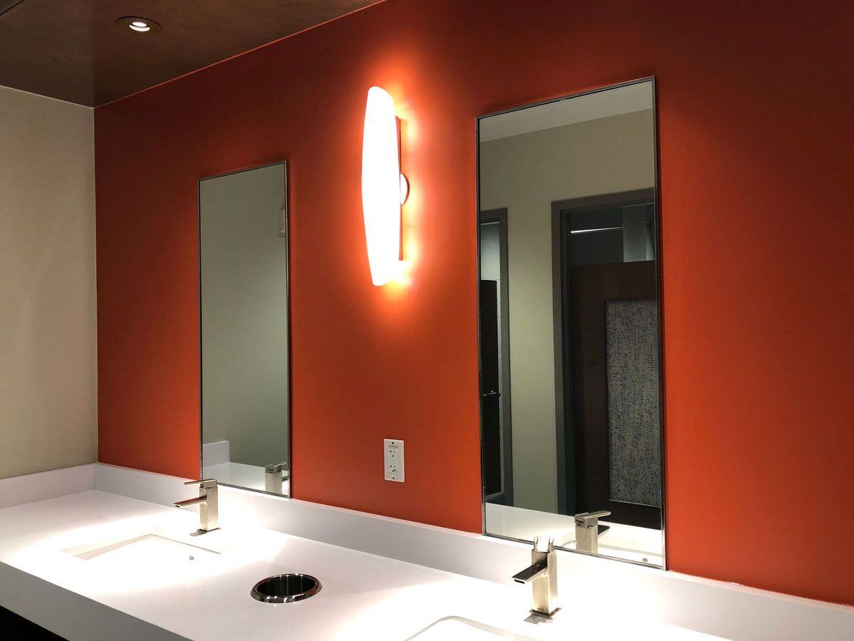 A door is open in a room with a red exit sign above it.