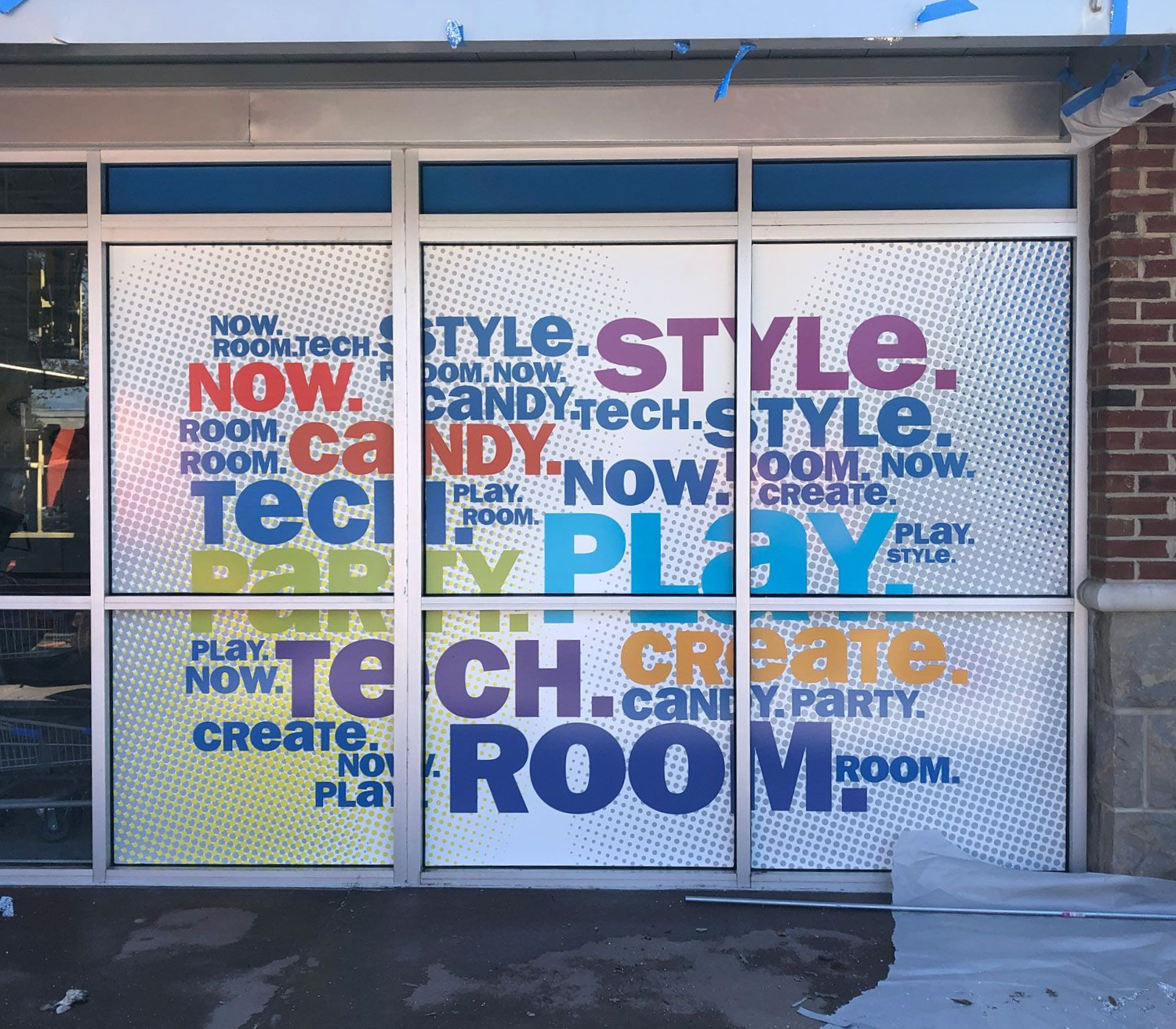 Storefront windows covered with colorful typography advertising room styling and tech design.