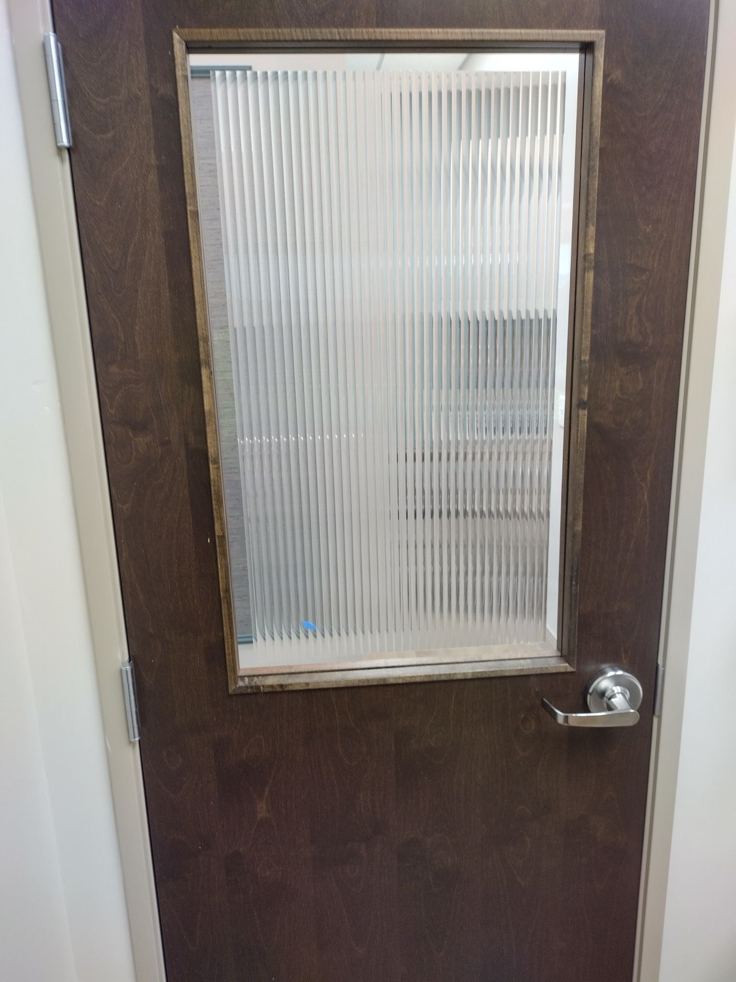 Brown door with a frosted glass window and silver handle