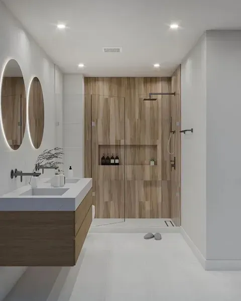 Modern bathroom with wood vanity, round mirrors, shower, and light wood door.