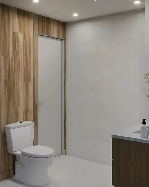 Modern bathroom with a toilet, wood-paneled wall, light tile, and a sink vanity