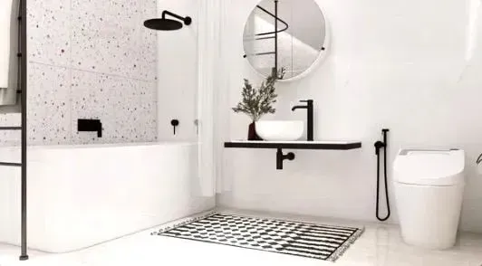 Minimalist white bathroom with walk-in shower, round mirror, black accents, and a white toilet