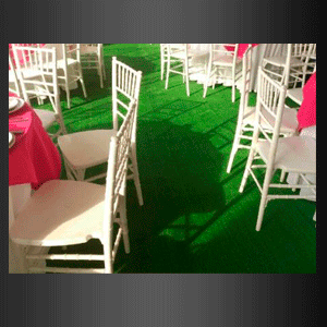 Una fila de sillas blancas están colocadas sobre una alfombra verde.