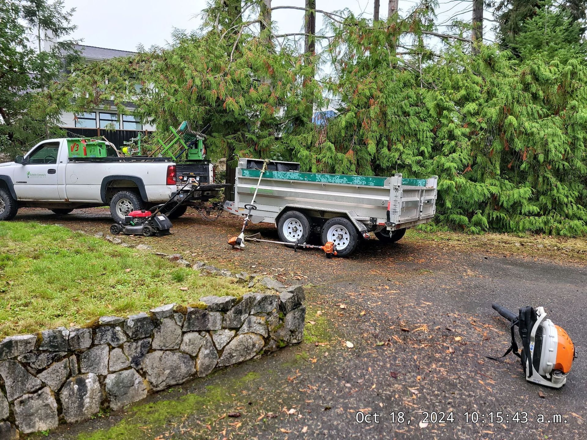 A truck is towing a trailer with a lawn mower attached to it.
