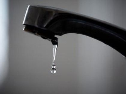 Black faucet dripping water, indoors.