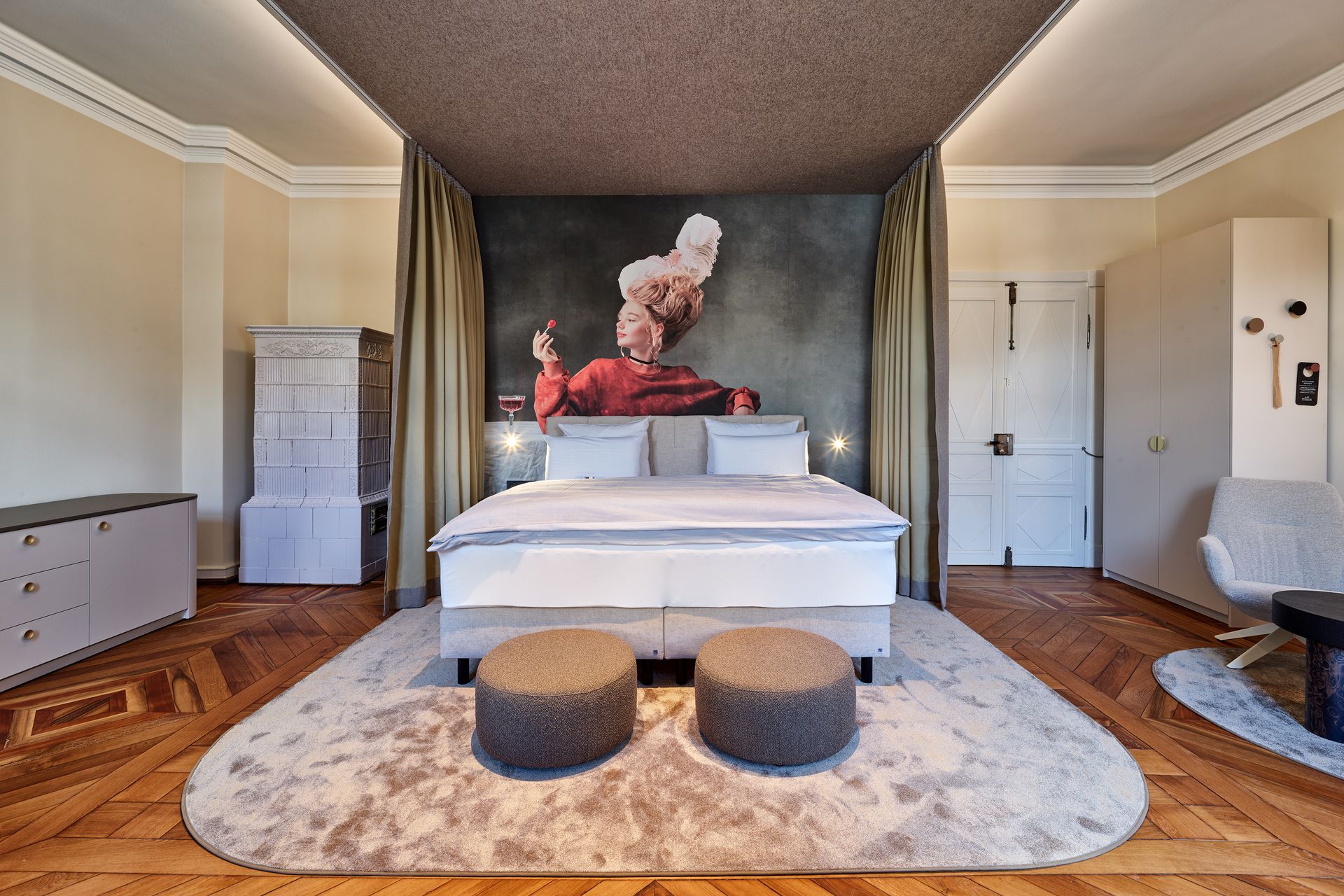 Schlafzimmer mit großem Bett, Teppich, Bildern an der Wand und Holzboden.