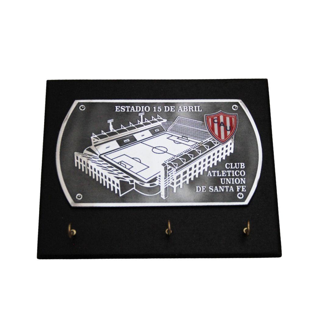 Placa con grabado del estadio y escudo del Club Atlético Colón–Santa Fe sobre una tabla negra.