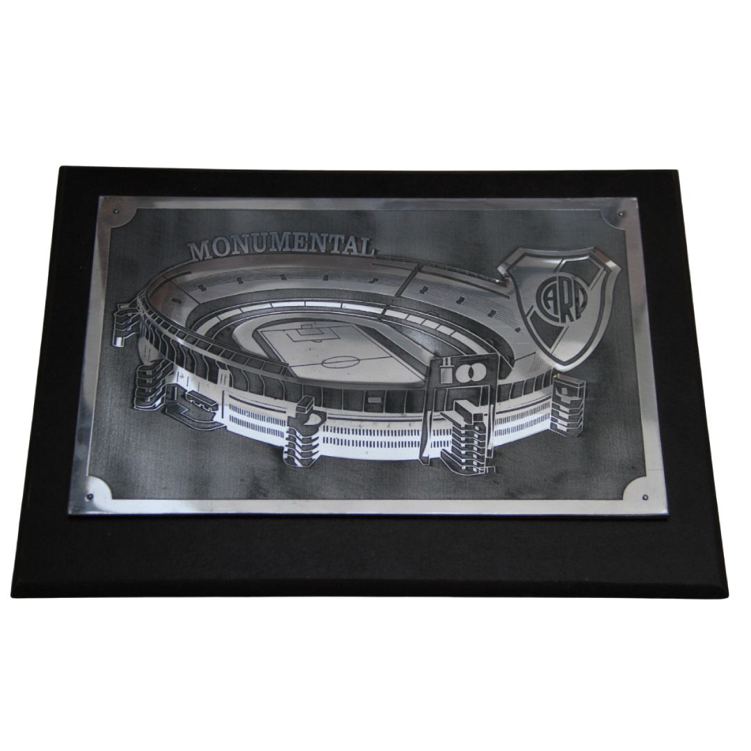 Placa plateada con marco negro, grabado de un estadio y texto “MONO MENTAL”.