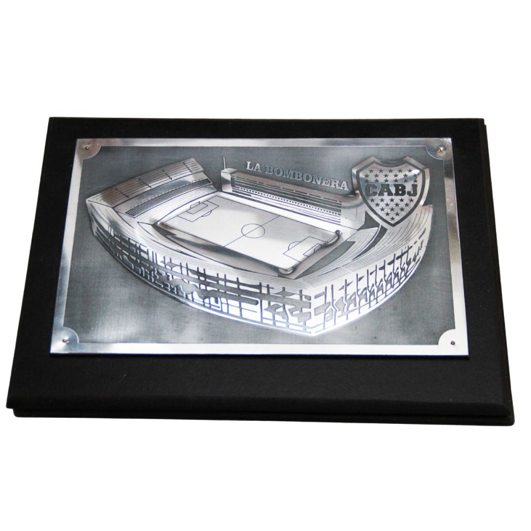 Placa plateada con marco negro, grabado de un estadio y texto “MONO MENTAL”.