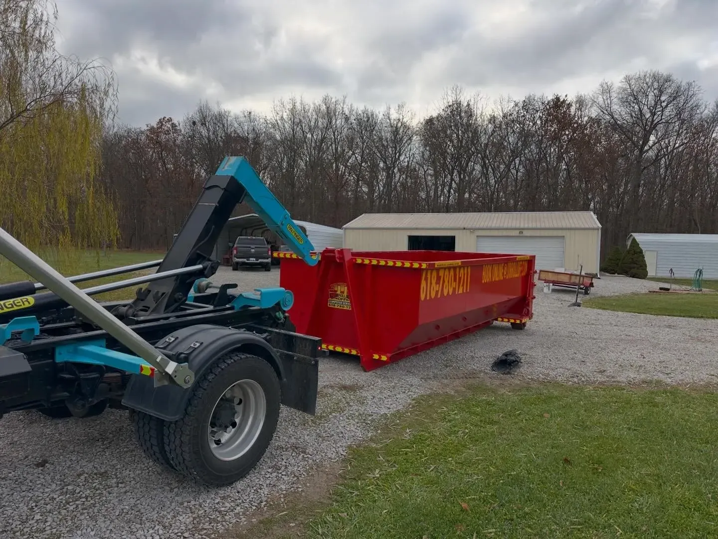 A red dumpster is sitting on top of a trailer.